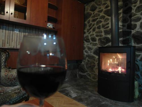 a glass of wine in front of a fireplace at Mestia 4 season in Mestia