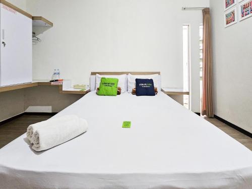 a large white bed with two pillows on it at Urbanview Java Living Sigura Gura in Betek