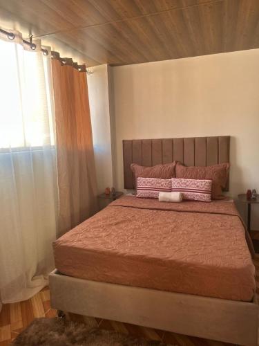 a bedroom with a large bed with pink pillows at Wiracocha Apartments #4 in Pisac