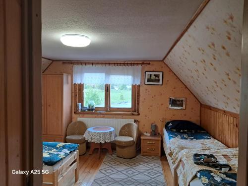 a room with two beds and a table in a attic at Olsik in Białowieża