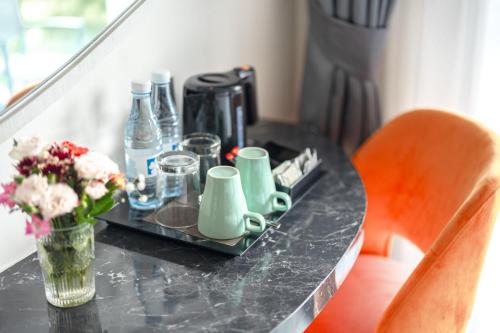 a black table with a vase of flowers and drinks at Hotel Clover Patong Phuket in Patong Beach