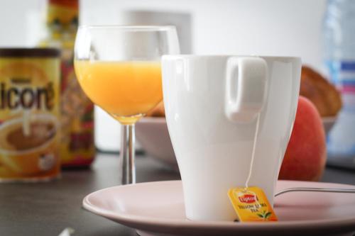 une tasse de café et un verre de jus d'orange dans l'établissement Résidence les Cèdres, à Strasbourg