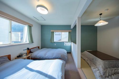 a bedroom with two beds and a couch in it at TANIGAWA GOODY Lodge in Minakami