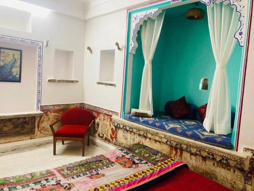 a room with a bed and a chair and a mirror at Little Peepal House in Udaipur