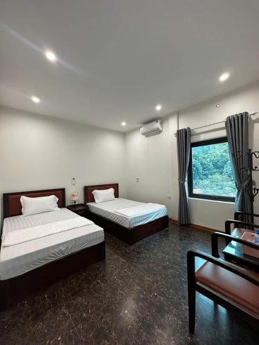 a bedroom with two beds and a desk and a window at Bích Giản Tràng An in Nguyên Ngoại