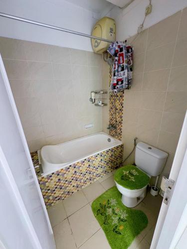 a bathroom with a tub and a toilet and a bath tub at Arcovella House in Cikarang