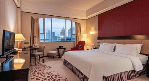 a hotel room with a large bed and a large window at Shunde Emperor Hotel in Shunde
