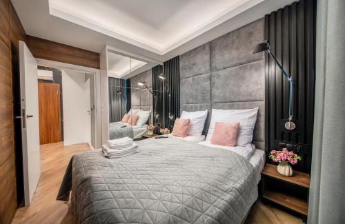 a bedroom with a large bed with pink pillows at Apartament Bursztynowa Komnata 117 Stegna nad morzem in Stegna
