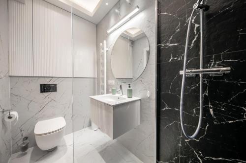 a bathroom with a toilet and a sink and a mirror at Apartament Bursztynowa Komnata 117 Stegna nad morzem in Stegna
