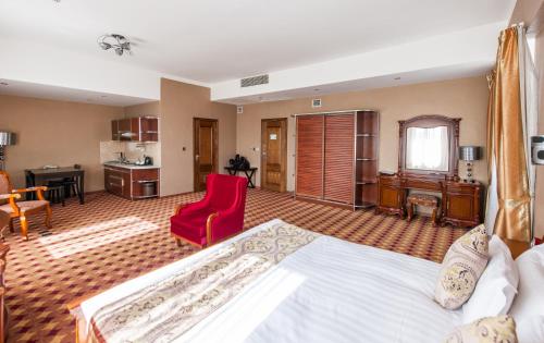 a large room with a bed and a red chair at UB City Hotel in Ulaanbaatar