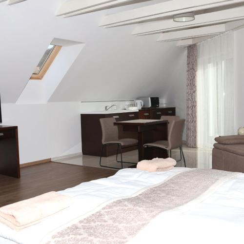 a bedroom with a bed and a desk and a table at Viktória Vendégház in Eplény