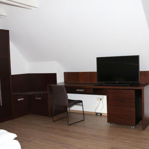 a desk with a computer and a chair in a room at Viktória Vendégház in Eplény