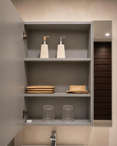 a bathroom with a sink and a shelf with towels at D'Élite Boutique Hotel Dĩ An in Dĩ An