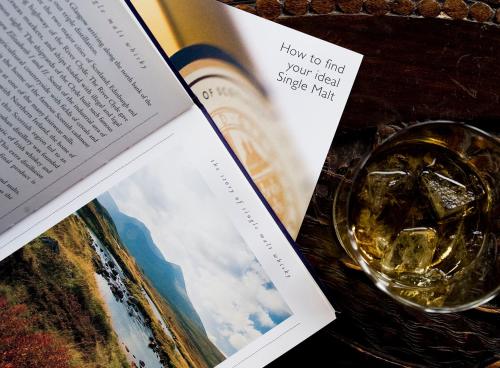 a book on a table with a glass of wine at One Devonshire Gardens a Hotel Du Vin in Glasgow