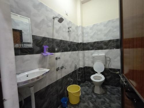a bathroom with a sink and a toilet and a mirror at Pramod Residency in Chitrakoot