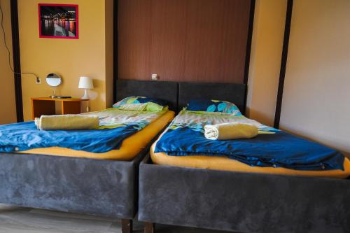 two beds sitting next to each other in a room at Lukanov Apartments & Guest Rooms in Ohrid