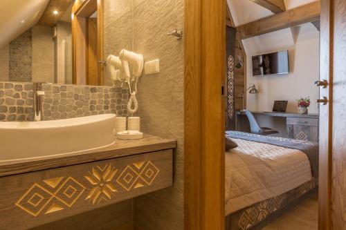 een badkamer met een bad, een wastafel en een bed bij Dom Gościnny Bachledova in Zakopane