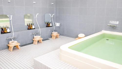 a bathroom with two toilets and a bath tub at Center Hotel Mihara in Mihara