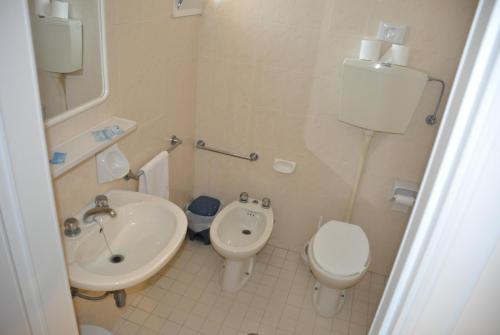 ein kleines Bad mit einem Waschbecken und einem WC in der Unterkunft Hotel Orchidea in Cesenatico
