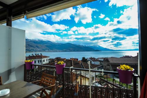 a balcony with a view of the water and mountains at Lukanov Apartments & Guest Rooms in Ohrid