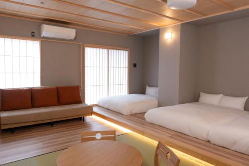 a room with two beds and a couch and a table at Tousumi in Fukuoka