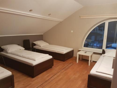 a room with two beds and a window at Duszka Hostel in Warsaw