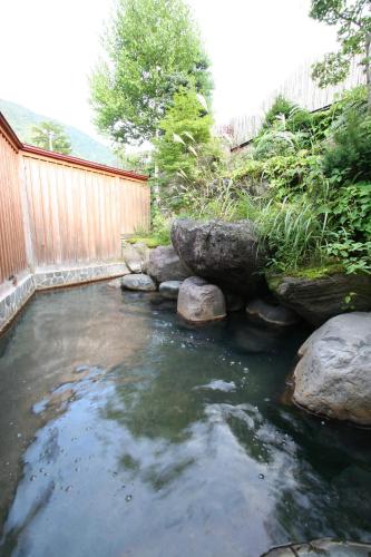 a pool of water with rocks in a backyard at Nakamurakan in Takayama