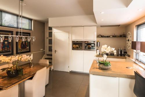 a kitchen with white cabinets and a wooden table at Houseboat-Apartment Sumatra in Amsterdam