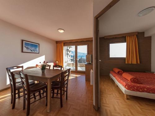 a bedroom with a dining room table and a bed at Noemys Ecrin des Neiges in Chamrousse