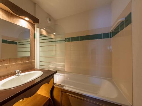a bathroom with a sink and a tub at Noemys Ecrin des Neiges in Chamrousse