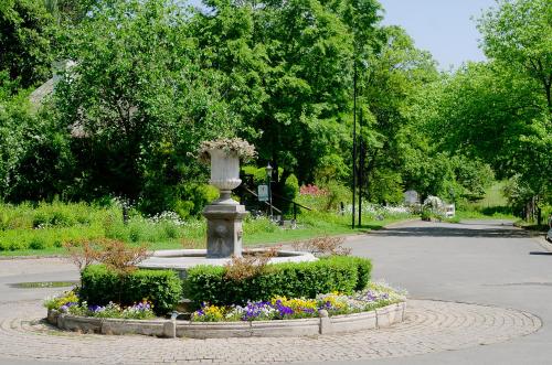 a statue in a garden with flowers in a park at Rawdons Hotel & Brewery in Nottingham Road