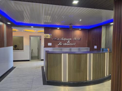 a lobby with a bar in the middle of a building at Mandapam Hotel & Restaurant in Dhanbād
