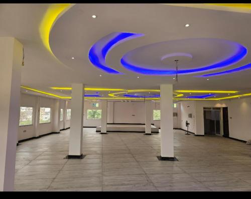 a large room with blue lights on a ceiling at Mandapam Hotel & Restaurant in Dhanbād