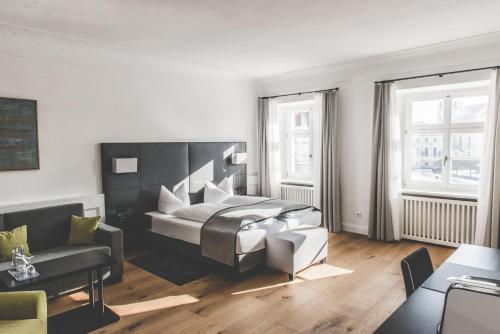 a living room with a bed and a couch at Hotel Münchner Hof in Altötting