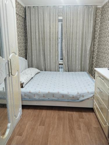 a small bedroom with a bed and a window at ИП Саялы in Balqash