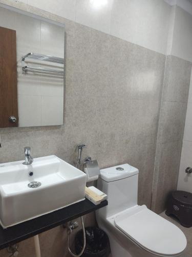 a bathroom with a sink and a toilet and a mirror at Sri Sai Comforts Manyata Tech Park in Bangalore