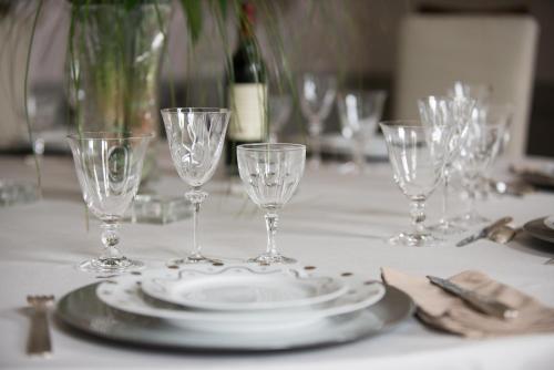 a table with glasses and plates on a table at La Tillaie SPA et Sauna in Pont-lʼAbbé-dʼArnoult