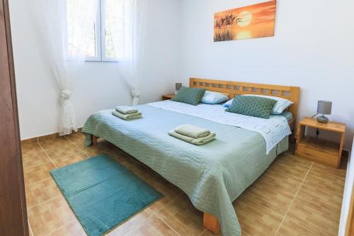 ein Schlafzimmer mit einem Bett, auf dem zwei Handtücher liegen in der Unterkunft Apartments Dalia in Vis
