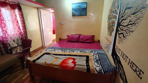 a small bedroom with a bed with a wooden frame at Emerald home stay in Kodaikānāl