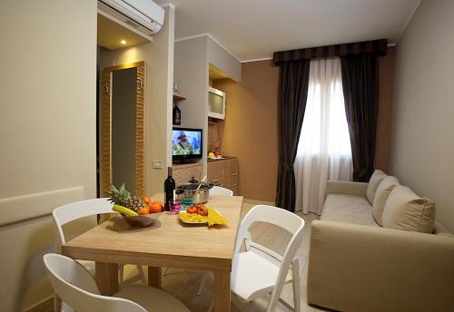 a living room with a table and chairs and a couch at Hotel C'era Una Volta in Castiglione della Pescaia