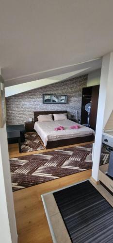 a bedroom with a bed and a brick wall at Aspen golf studio B402 in Razlog