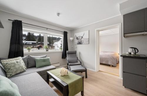 a living room with a couch and a room with a bed at Spåtind Fjellhotell in Nord Torpa