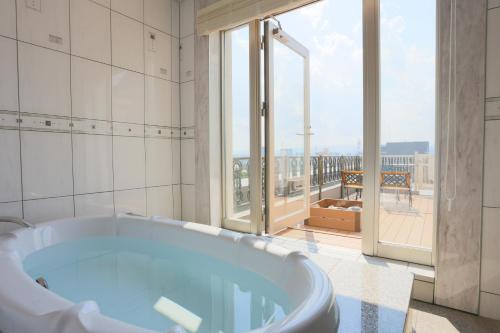 a bath tub in a bathroom with a balcony at Hotel Castle Inn Tsu in Tsu