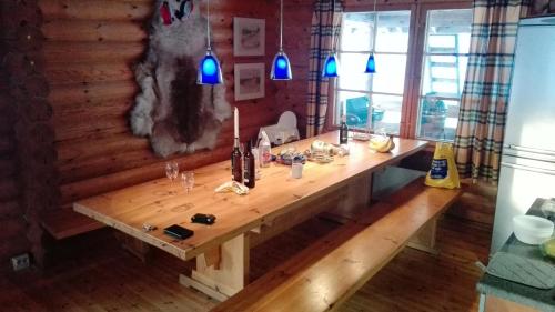 a wooden table with bottles of wine on it at Kuulapää Chalet in Äkäslompolo