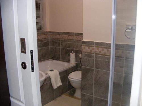 a bathroom with a toilet and a bath tub at At 29 Columba in Groot Brak Rivier