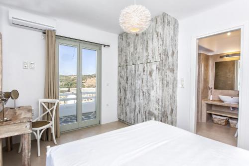 a bedroom with a bed and a desk and a bathroom at Glyfada's Villa in Kastraki Naxou