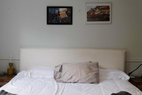 a bed with white sheets and a pillow on it at Bright & Spacious Full Family Home in Vancouver