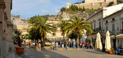 a group of people walking down a street with palm trees at Casa Mia holiday in Scicli in Scicli