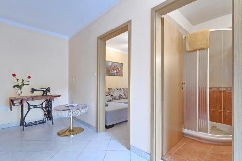 a room with a bed and a table and a mirror at Apartments Valoda in Nedeščina