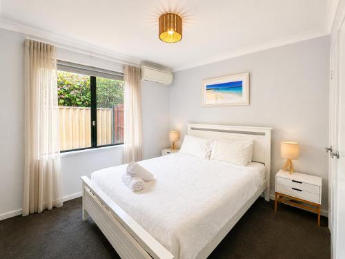 a bedroom with a white bed and a window at Longer Days at Halcyon Daze in Dunsborough
